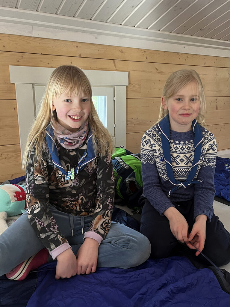 Två små flickor sitter bredvid varanda på loftet.