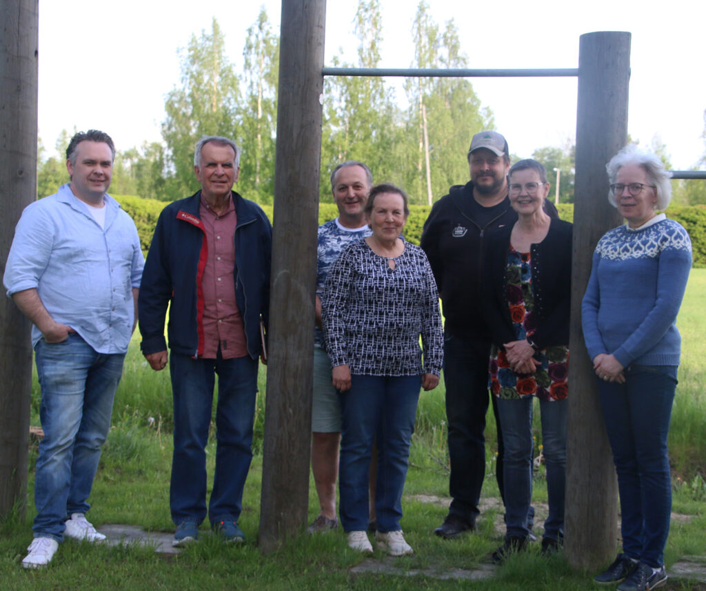 En grupp av bybor står på byagården i Forsby.