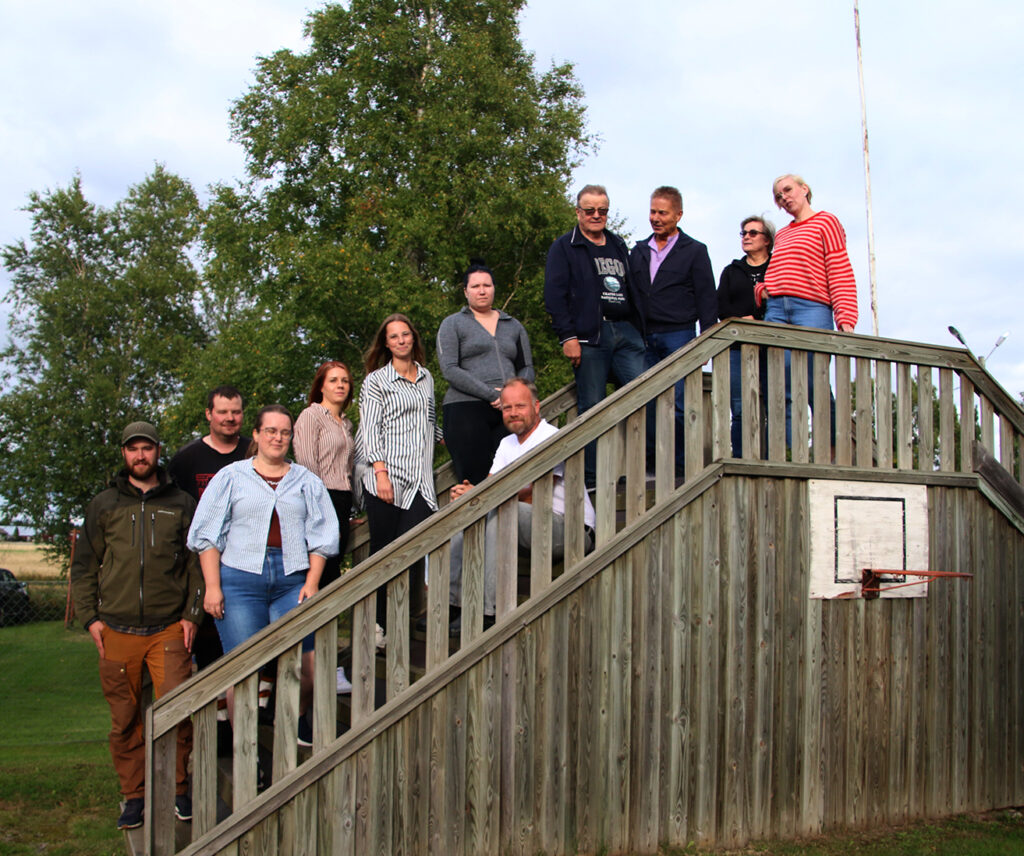 En grupp föreningsaktiva står brevid varandra på gården.